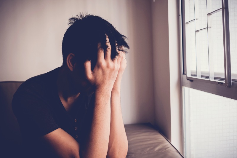 Hombre joven deprimido, desesperado y ansioso sentado solo en casa, ansiedad, síntomas de ansiedad